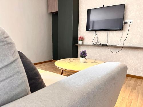 a living room with a tv and a couch and a table at HillLand Suites in Ayer Keroh