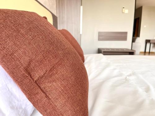 a brown pillow sitting on top of a bed at HillLand Suites in Ayer Keroh