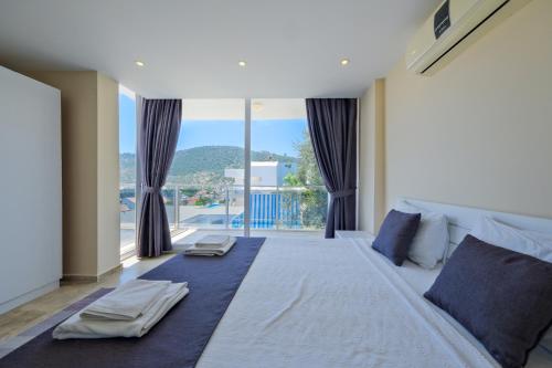 una camera da letto con un grande letto con una grande finestra di Lumiere Villas 2 a Kalkan