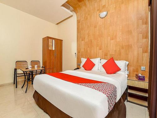 1 dormitorio con 1 cama grande con almohadas rojas en OYO Royal Plaza Residence -3, en Ras al Khaimah