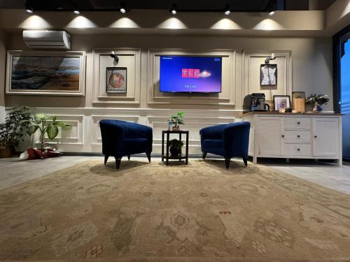 a waiting room with two blue chairs and a tv at Loft Plus Hotel's in Arnavutköy