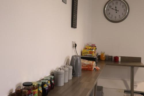 a kitchen counter with cans of food and a clock at Kop View in Liverpool