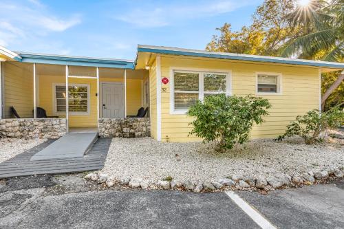 a yellow house with a driveway in front of it at Blackfin Resort and Marina in Marathon
