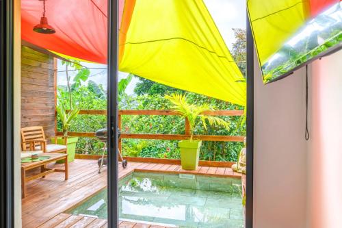 een patio met een zwembad en een parasol bij Le planteur in Rivière-Pilote