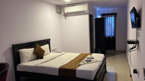 a bedroom with a bed in a room with a television at THE METRO INTERNATIONAL HOTEL in Hyderabad