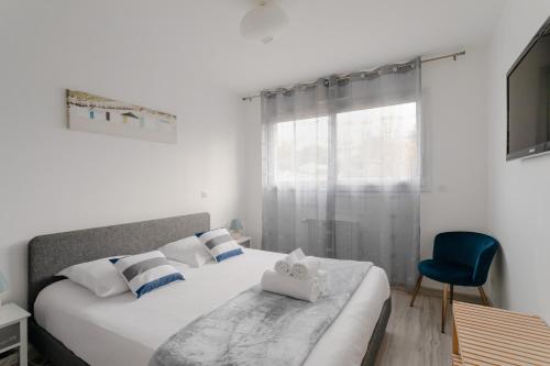 une chambre avec un lit et une chaise bleue dans l'établissement Rosamaris - Maison pour 8 avec jardin, à Saint-Malo