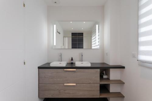 une salle de bain avec deux lavabos et un miroir dans l'établissement Rosamaris - Maison pour 8 avec jardin, à Saint-Malo