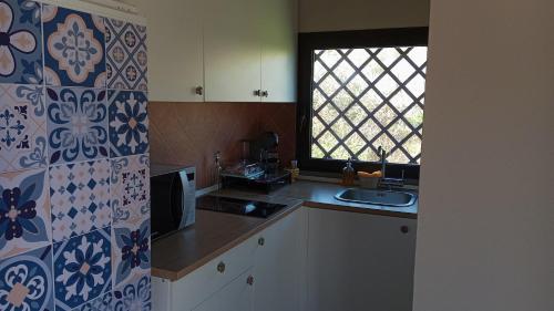 uma cozinha com um lavatório e uma janela em Ai tre desideri la casita em Aci Castello