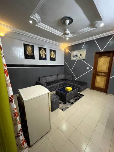 a living room with a couch and a refrigerator at Fredy meublé in Ouagadougou