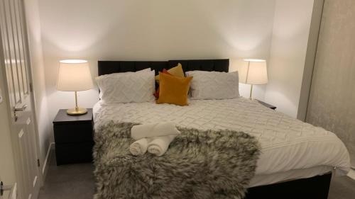 a bedroom with a large bed with two lamps at LUXURY 3 BED HOME with MULTIPLE FREE PARKING BAYS Early Check-in Late Check- Out Allowed in West Thurrock