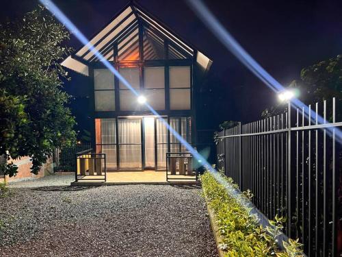 a house with a fence and lights in front of it at El refugio del Guayacán in Manizales