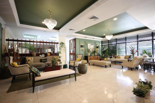 a living room with couches and tables and chairs at Courtleigh Hotel & Suites in Kingston