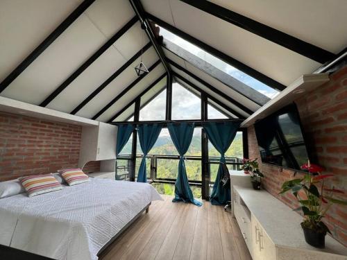 a bedroom with a bed and a large window at El refugio del Guayacán in Manizales