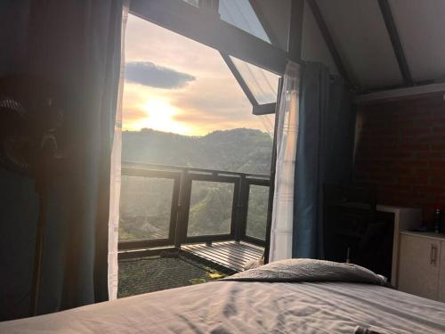 a bedroom with a bed and a window with a view at El refugio del Guayacán in Manizales