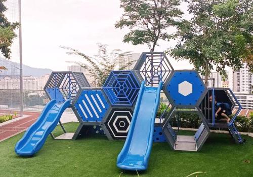 un parque infantil con un tobogán azul en el césped en Romantic Sea View Room @ Urban Suites, Jelutong, en Jelutong
