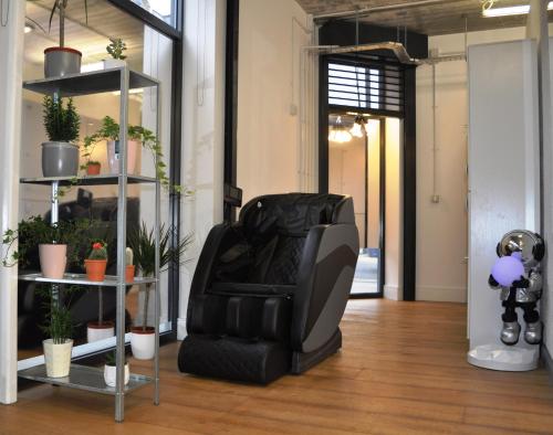 a black leather chair in a room with plants at Cosmos capsule coworking London in London