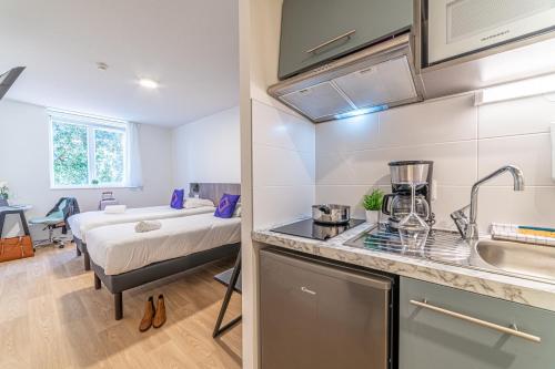 une cuisine et une chambre avec un lit dans une pièce dans l'établissement Montempô + Apparthôtel Toulouse Cité Internationale, à Toulouse