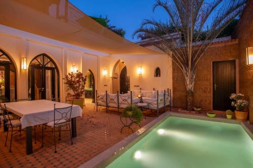 a patio with a table and a swimming pool at Dar Ines - Palmeraie, 250m2, pool, patio, terrace in Marrakech