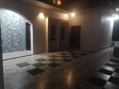 an empty room with a checkered floor in a building at Jabal Shams bayt kawakib in Misfāh