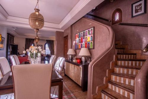 a dining room with a table and chairs and a staircase at Dar Ines - Palmeraie, 250m2, pool, patio, terrace in Marrakech