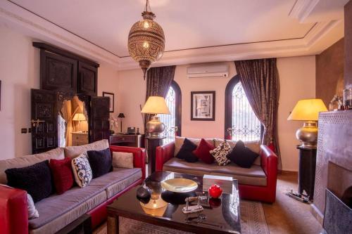 a living room with two couches and a table at Dar Ines - Palmeraie, 250m2, pool, patio, terrace in Marrakech