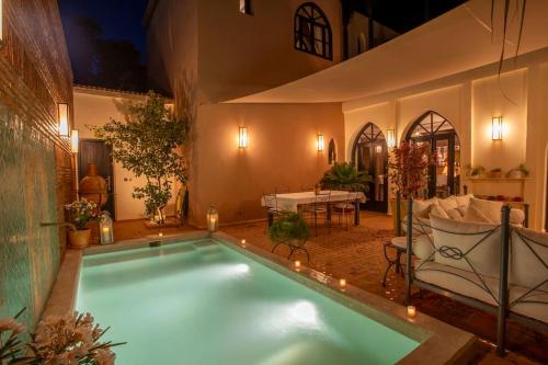 a large swimming pool in a room with a table at Dar Ines - Palmeraie, 250m2, pool, patio, terrace in Marrakech