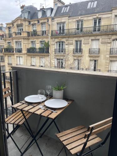 a table and chairs on a balcony with a building at Les Belles Feuilles Appartement in Paris