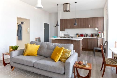 a living room with a couch and a kitchen at Spacious beach front apartment with stunning sea views in Deal