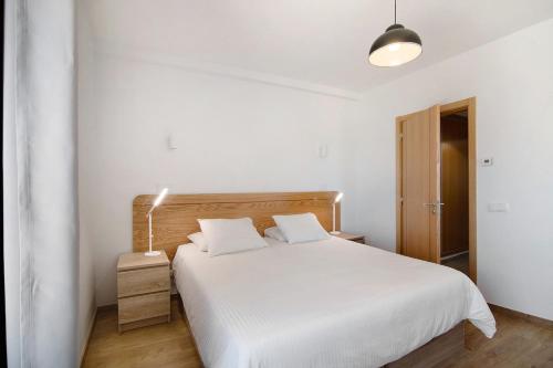 sypialnia z białym łóżkiem i lampką w obiekcie Quinta da Bornacha - Casa A w mieście Vila Nova De Cacela