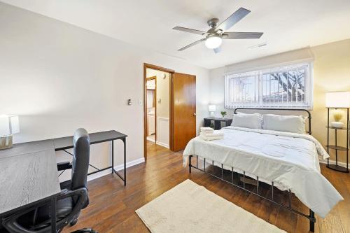 Un dormitorio con una cama, un escritorio y un ventilador de techo. en Modern Cozy 1 Bedroom Apartment in Shelby Township, en Shelby