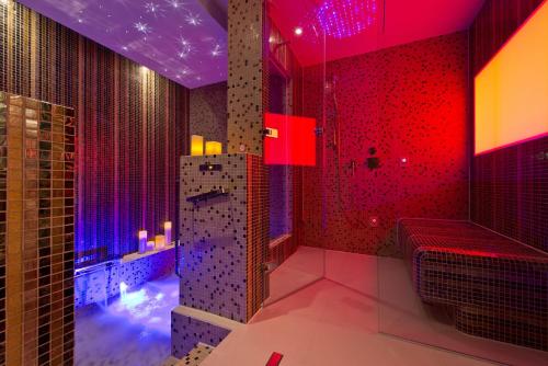 a bathroom with red and purple lighting and a shower at Steigenberger Icon Frankfurter Hof in Frankfurt