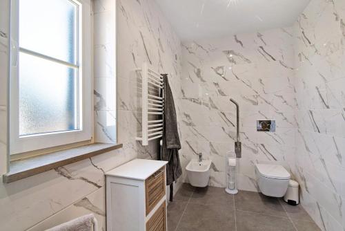 biała łazienka z toaletą i umywalką w obiekcie Quinta da Bornacha - Casa A w mieście Vila Nova De Cacela