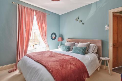 a bedroom with a bed with blue walls and a window at The Deal Abode - luxury self catering retreat in Deal
