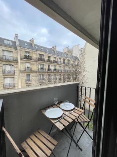 a balcony with a table and chairs and a building at Les Belles Feuilles Appartement in Paris