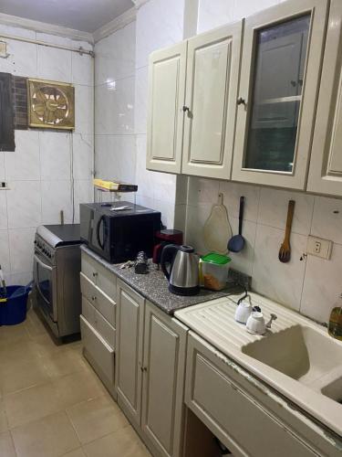a kitchen with a sink and a microwave at Live with local in central area in Cairo