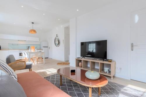 un salon avec un canapé et une table dans l'établissement Marcq en Baroeul two-bedroom bright and equipped, à Marcq-en-Barœul