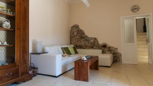 a living room with a white couch and a table at Villa Il Casale Onifai in Onifai
