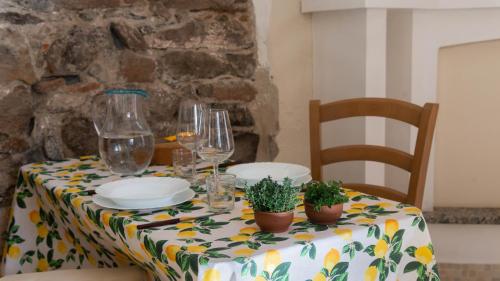 a table with glasses and plates and potted plants on it at Villa Il Casale Onifai in Onifai