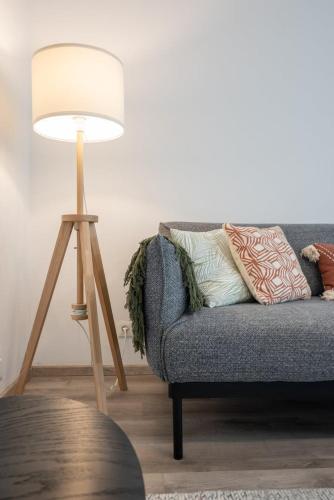 - une lampe dans le salon avec un canapé dans l'établissement Charming apartment with parking and balcony., à La Madeleine