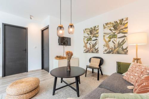 a living room with a couch and a table at Charming apartment with parking and balcony. in La Madeleine