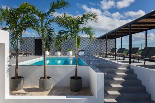 a swimming pool with two palm trees on a building at Coralia Hotel Cozumel in Cozumel