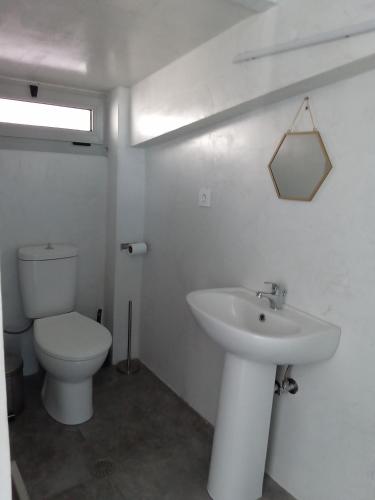 een witte badkamer met een toilet en een wastafel bij Petros house 3 in Nafplio