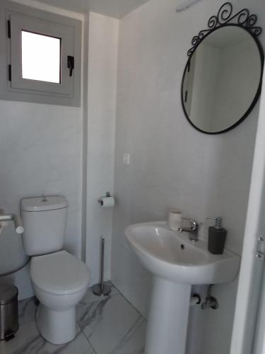 een witte badkamer met een toilet en een wastafel bij Petros house 3 in Nafplio