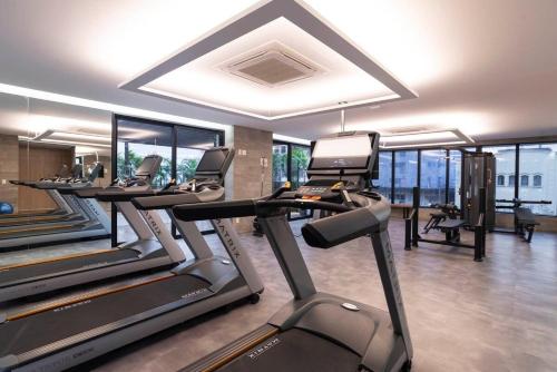 een fitnessruimte met een rij loopbanden en crosstrainers bij Nun Apartments by BnbHost in Sao Paulo