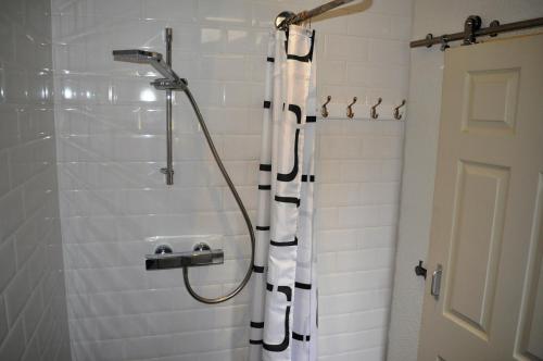 a shower with a black and white shower curtain at Cosmos capsule coworking London in London