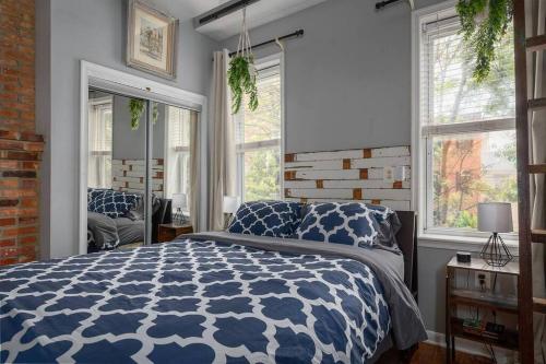 Un dormitorio con una cama y ventanas de color azul y blanco. en Johns Hopkins Historic Renovated home - Fells Point! en Baltimore