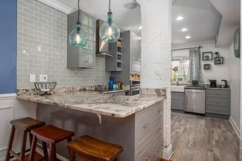 a kitchen with a large counter with stools in it at Johns Hopkins Historic Renovated home - Fells Point! in Baltimore