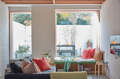 a living room with a couch and two windows at Two Rows Back From the Sea in Deal