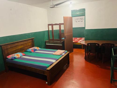 1 dormitorio con 1 cama, mesa y sillas en Sahas Guest House, en Boralesgamuwa