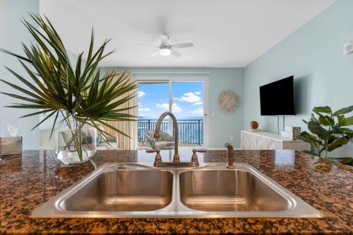 eine Küchenspüle mit Blick auf das Meer in der Unterkunft Sterling Breeze 1003 in Panama City Beach
